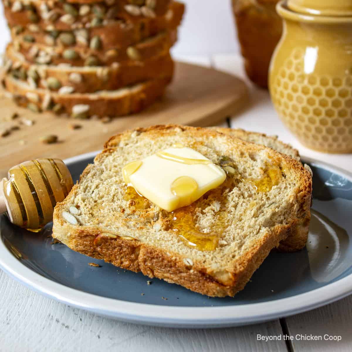 A toasted piece of bread topped with butter and honey.