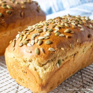 A loaf of bread topped with sunflower and pumpkin seeds.
