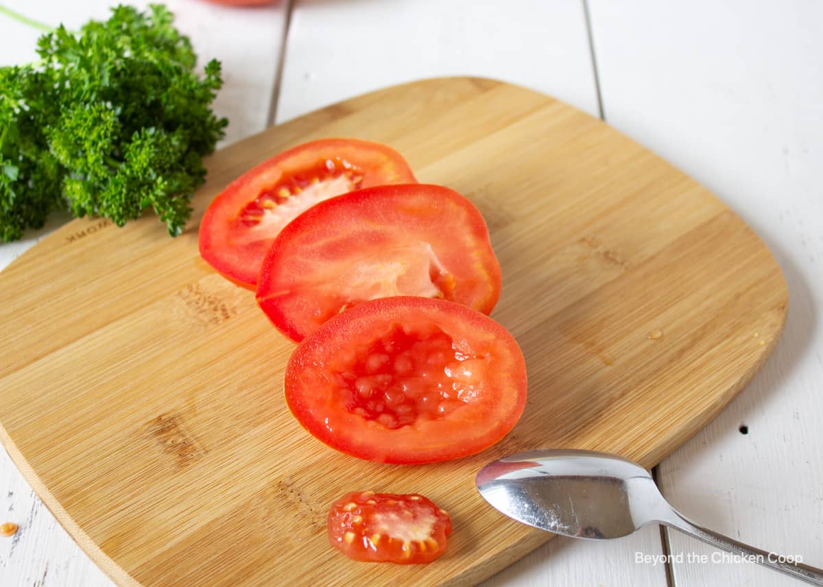 A slice tomato with the pulp scooped out of the tomato.