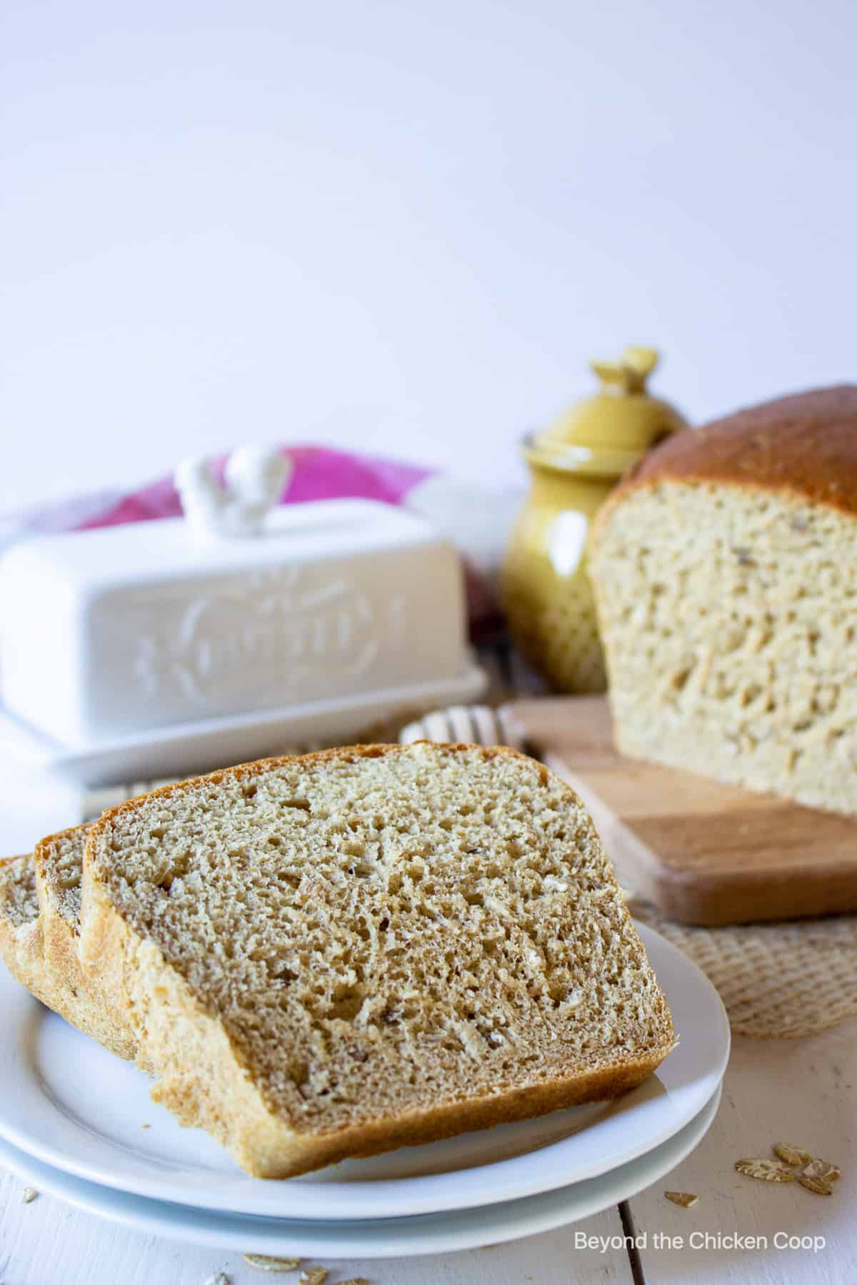 Sliced whole wheat bread on a small white plate.