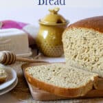 Sliced bread and loaf on a wooden cutting board.