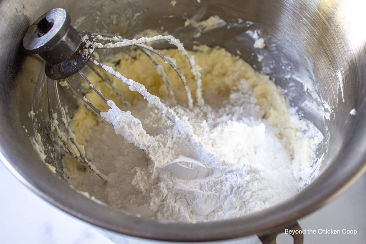 Powdered sugar added to a mixing bowl with butter.