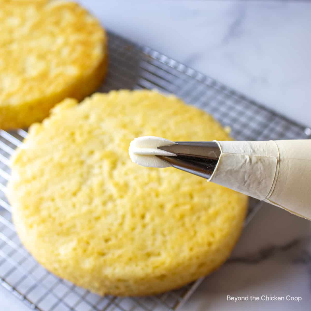 White frosting being squeezed out of a piping bag.