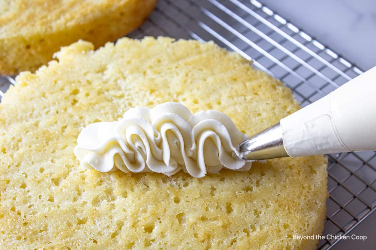 A swirl of piped frosting on a yellow cake.