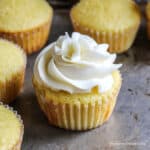 A yellow cupcake topped with a swirl of frosting.