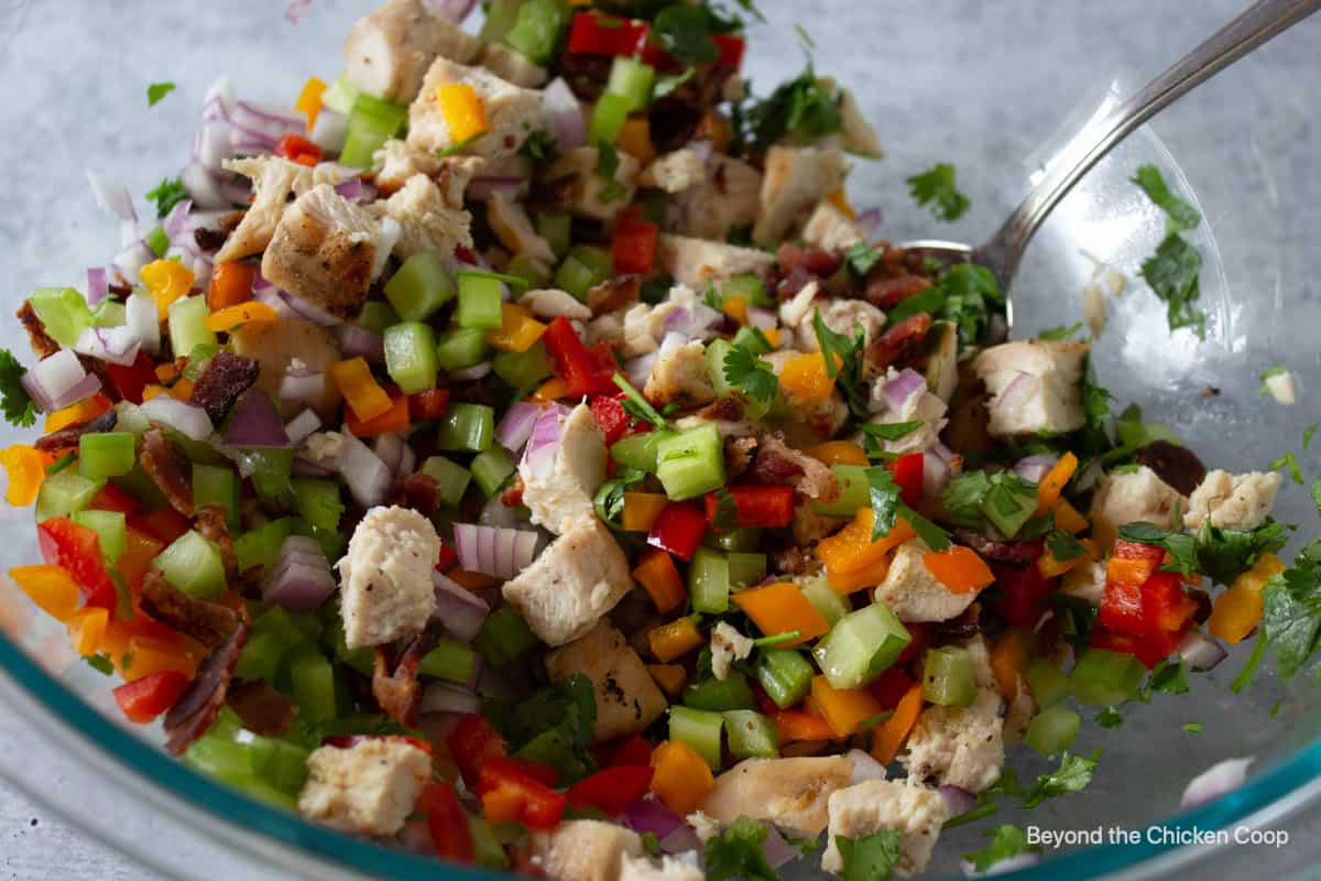 Chicken salad ingredients in a large glass bowl. 