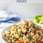 A bowl filled with a chicken salad with cilantro and bacon.