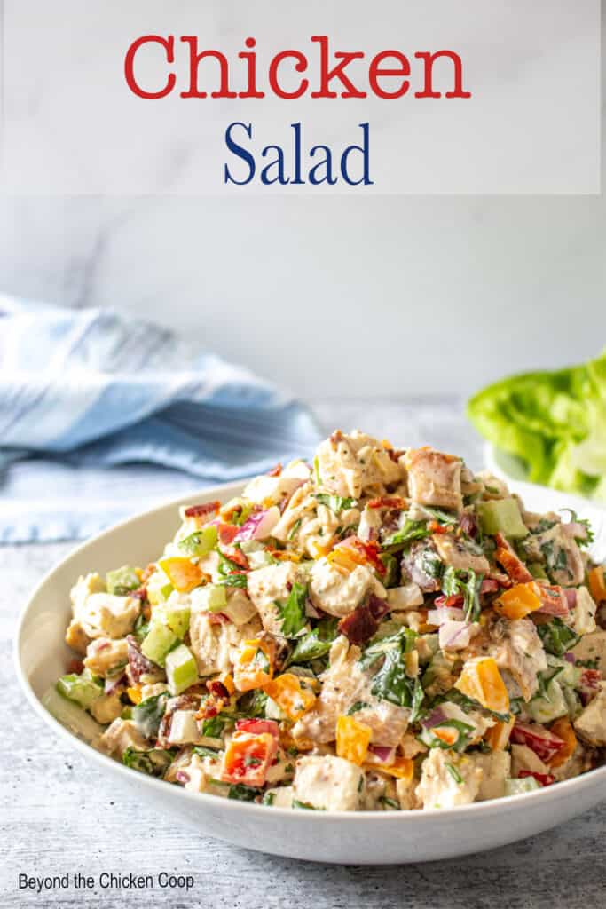A bowl filled with a chicken salad with cilantro and bacon.