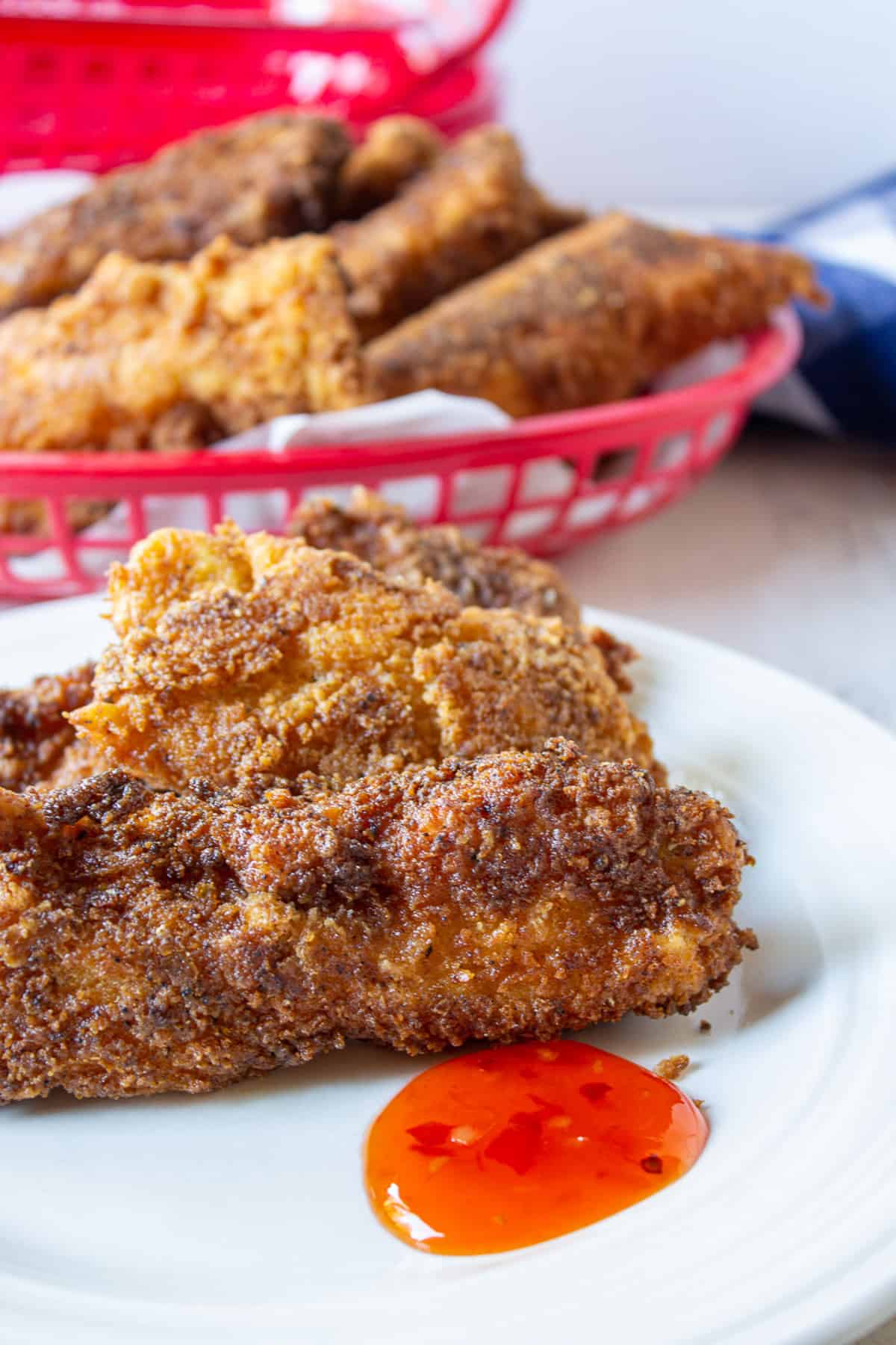 Chicken tenders on a plate with a red sauce.