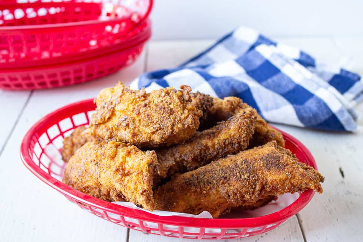 A red basket filled with chicken strips.