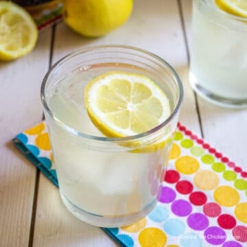 A glass filled with lemonade and a lemon slice.