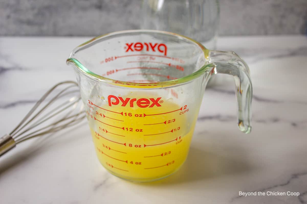 A glass measuring cup filled with lemon juice.