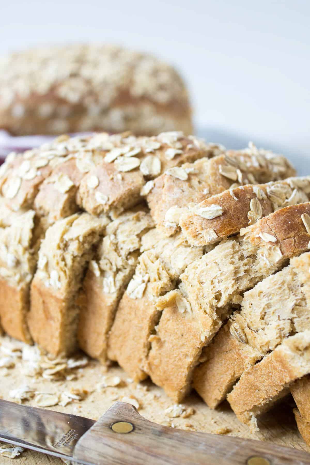 A loaf of sliced homemade bread on a bread board.