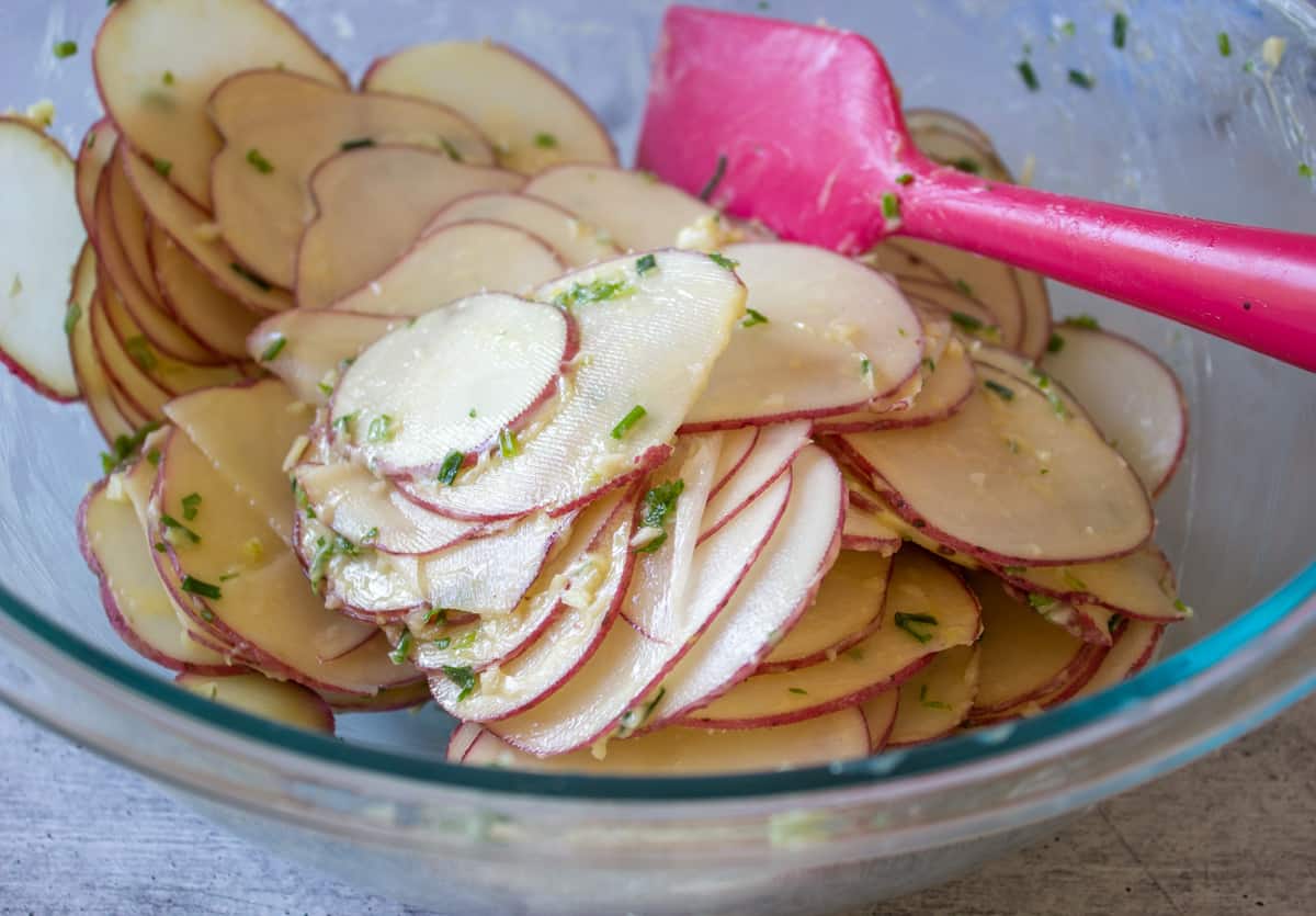 Sliced potatoes covered with butter and herbs.