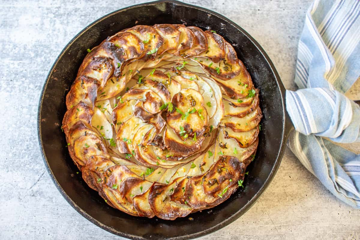 A cast iron skillet filled with crispy cooked potato slices.