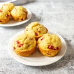 Three muffins on a small white plate.