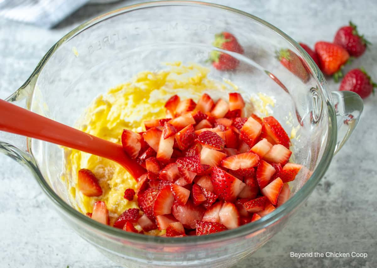 Chopped strawberries in a bowl with muffin batter.