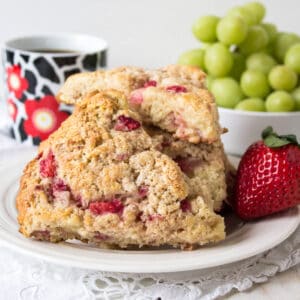 Two strawberry scones on a small white plate.