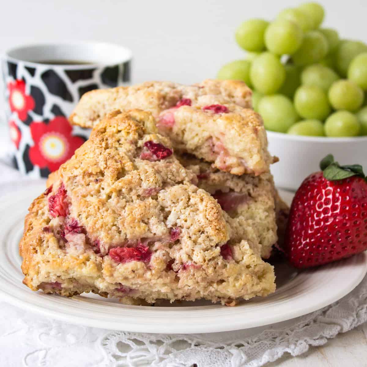 Two strawberry scones on a small white plate.