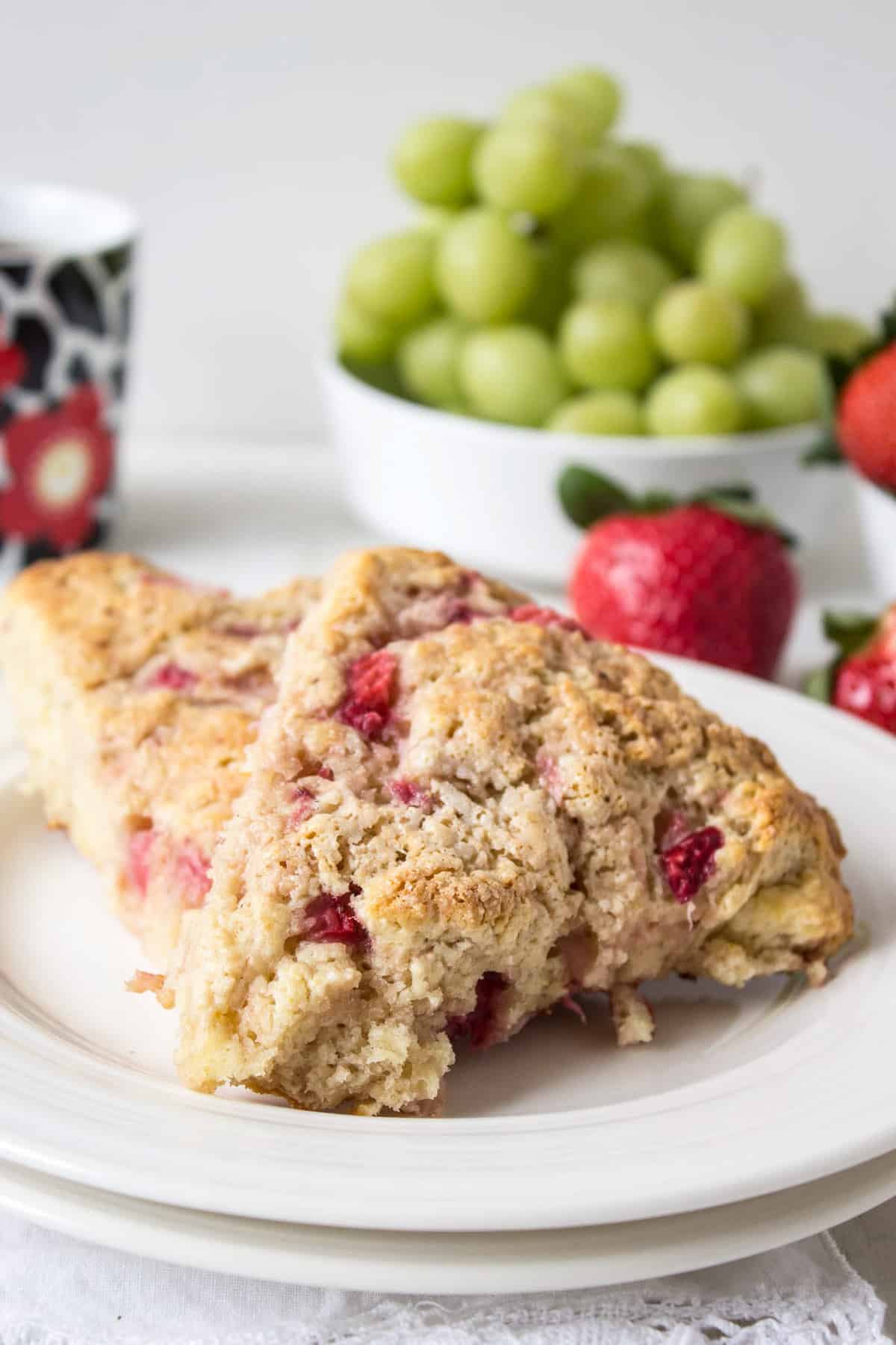 Two strawberry scones on a small white plate.