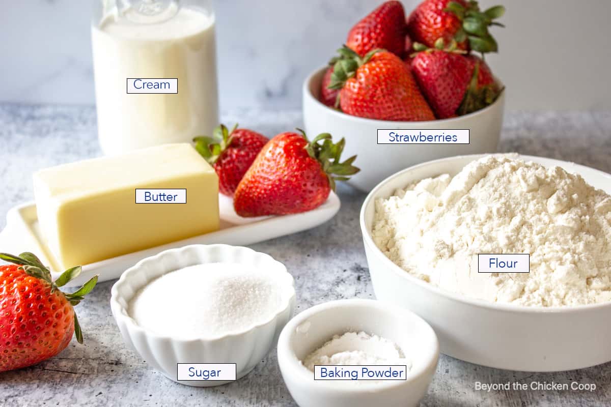 Small bowls filled with flour, sugar, flour and strawberries.