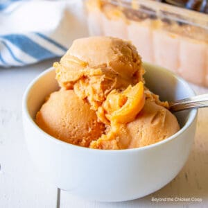 A bowl filled with orange ice cream.
