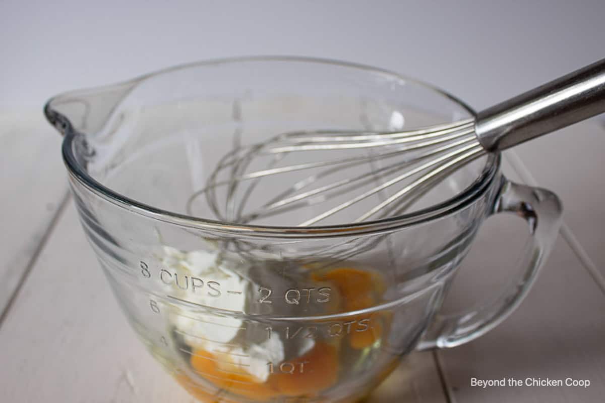 Sour cream and eggs together in a glass bowl.