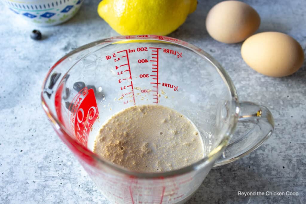 A measuring cup with milk and yeast.