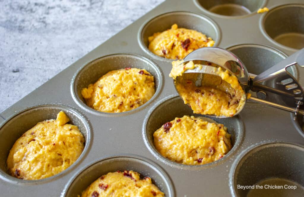 Scooping batter in to muffin tins.