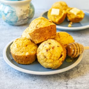 A pile of cornbread muffins on a blue plate.