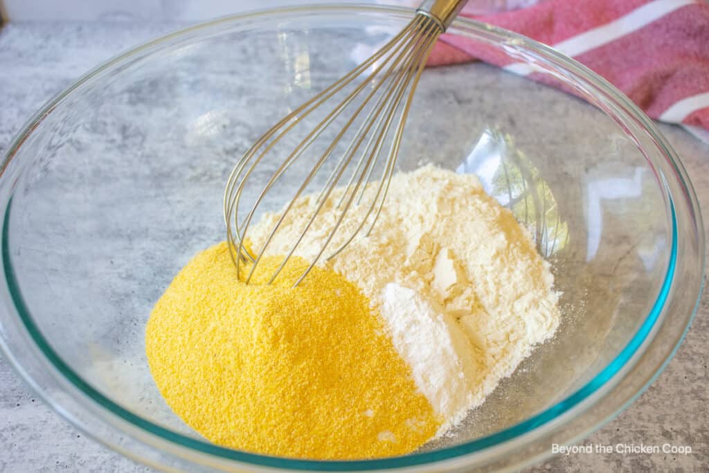 A glass bowl with cornmeal and flour.