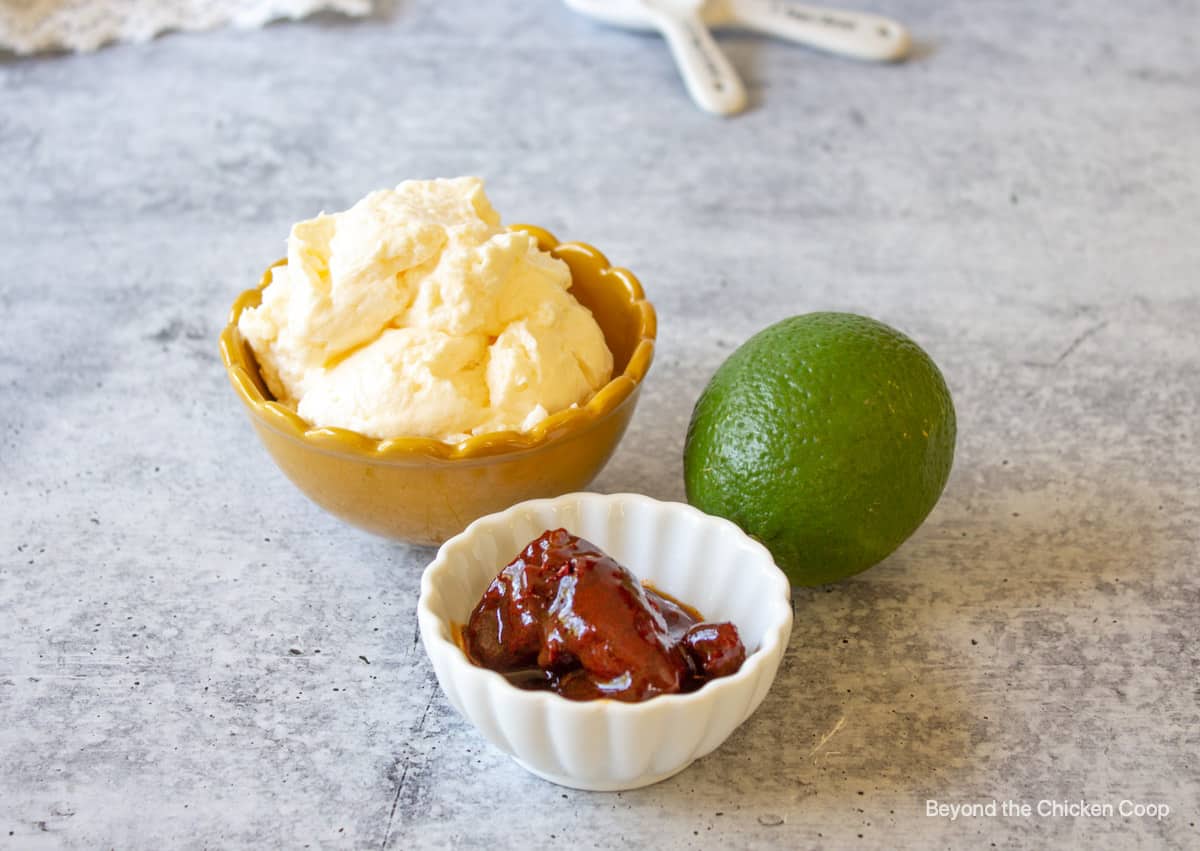 Two small bowl filled with mayonnaise and chipotle peppers.