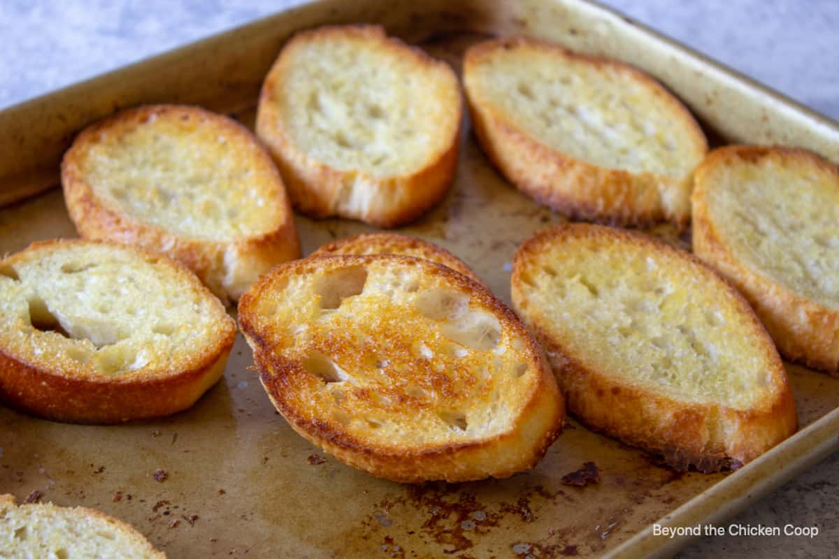 Toasted bread slices on a baking sheet.