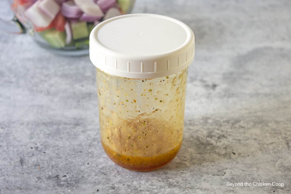 A vinaigrette dressing in a glass jar with a lid. 