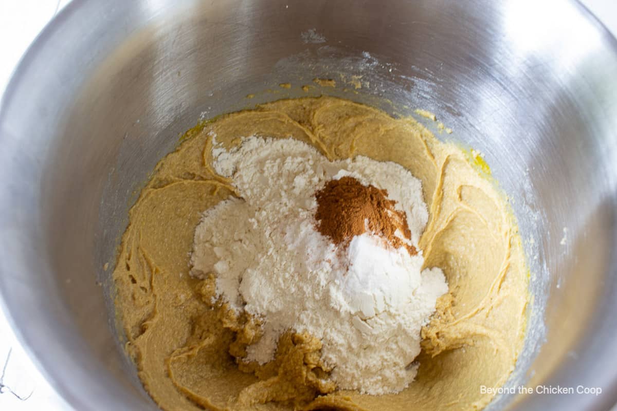 Flour and spices being added to cookie dough.