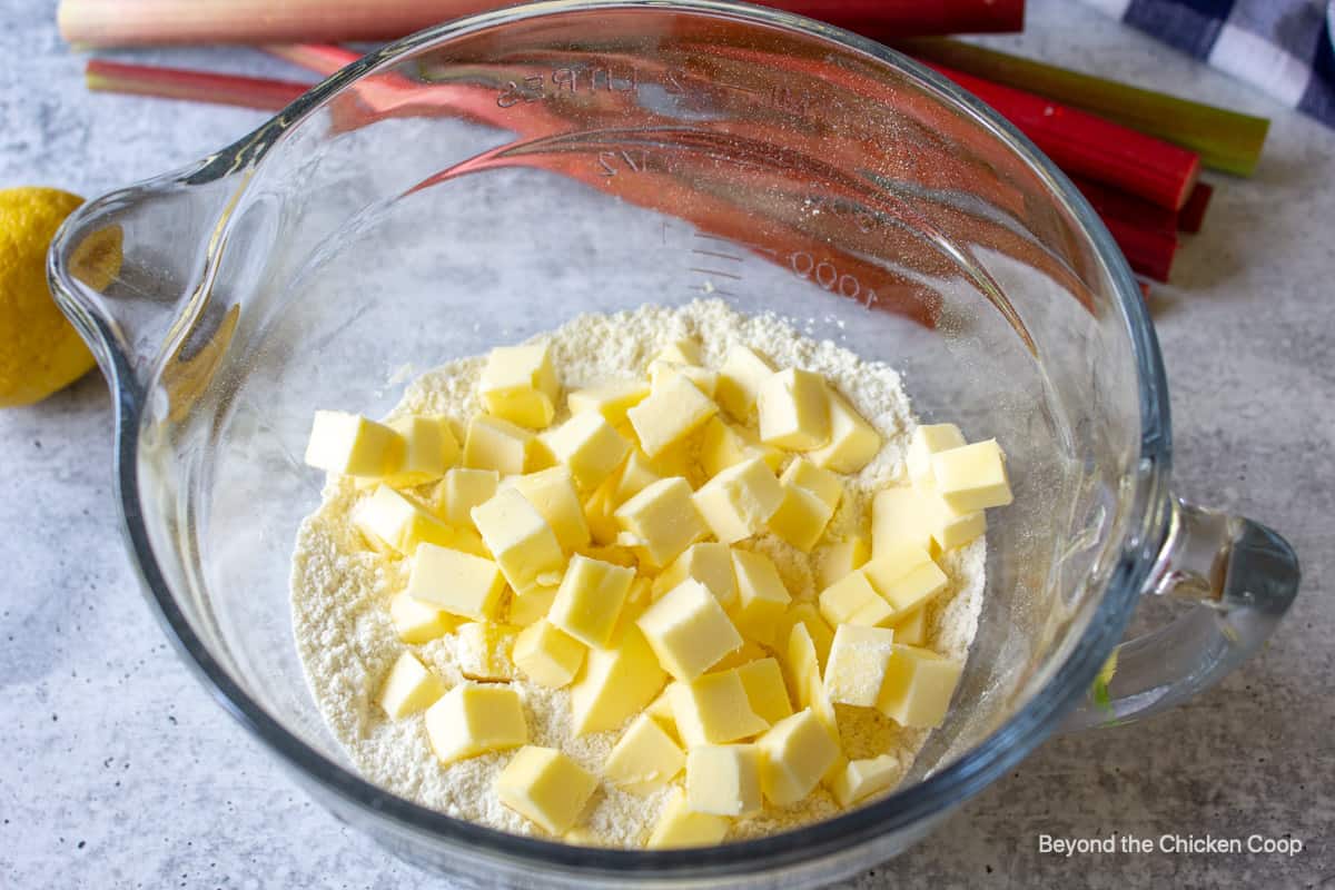 Small cubes of butter on top of flour in a bowl.