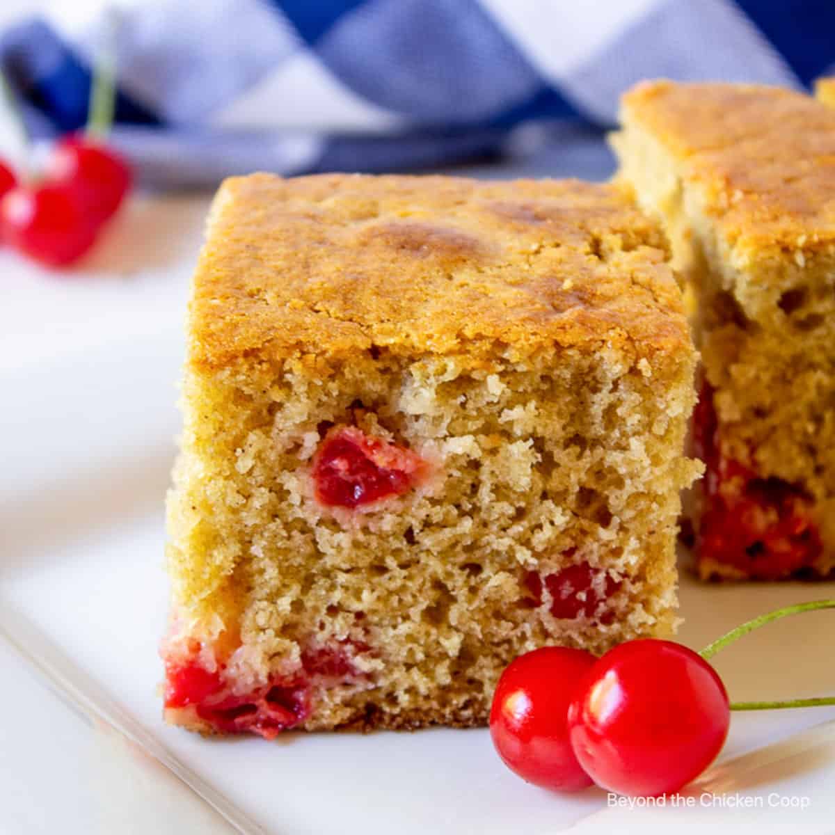 A slice of cherry cake on a white platter.