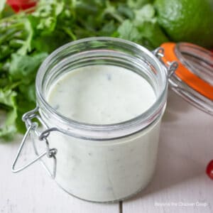 A glass crock filled with a creamy dressing.
