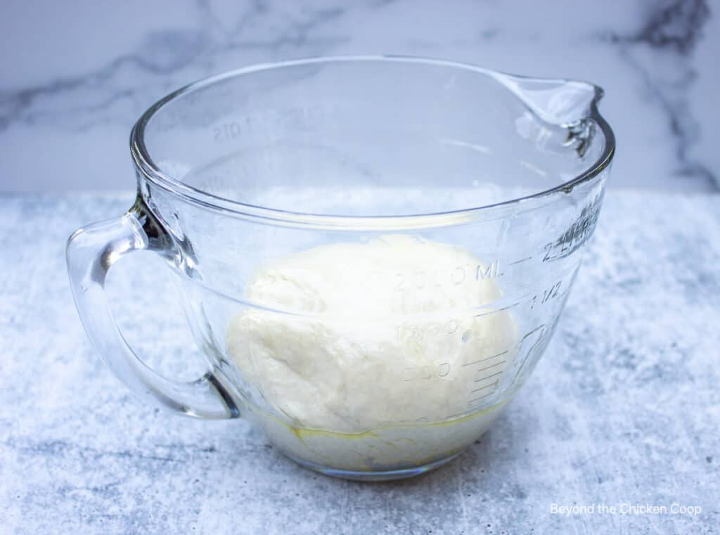 Bread dough in a glass bowl.