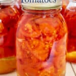 A canning jar filled with chopped tomatoes.