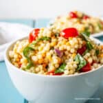 A couscous salad with tomatoes and spinach.