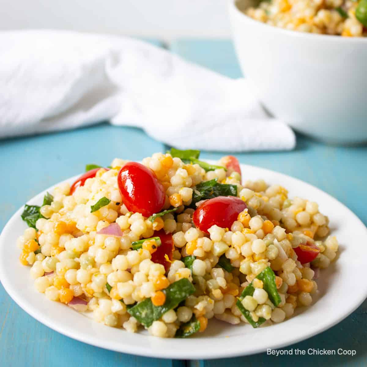 A plate filled with a tri colored couscous salad.