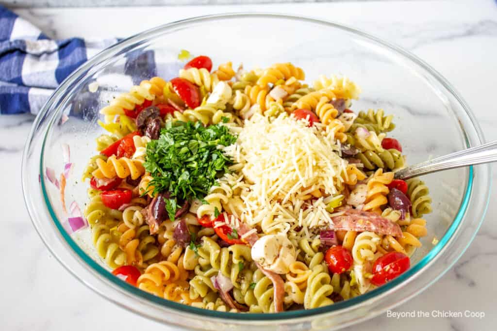 Chopped parsley and parmesan cheese on top of a pasta salad.