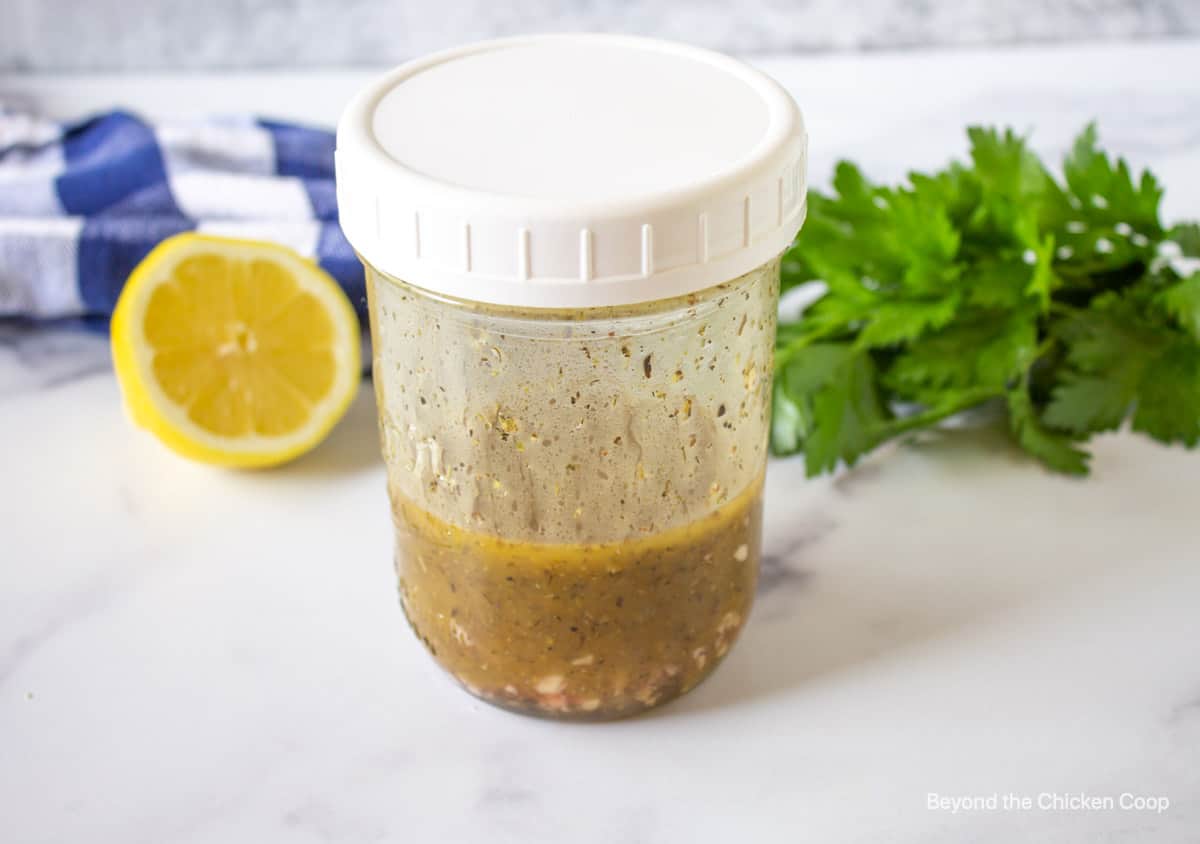 A mixed vinaigrette in a glass jar with a lid.