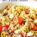 A pasta salad with tomatoes, cheese and salami.