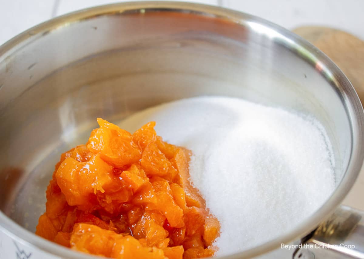 A pot with sugar and cut apricots.