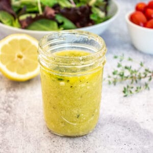 A yellow salad dressing in a glass canning jar.