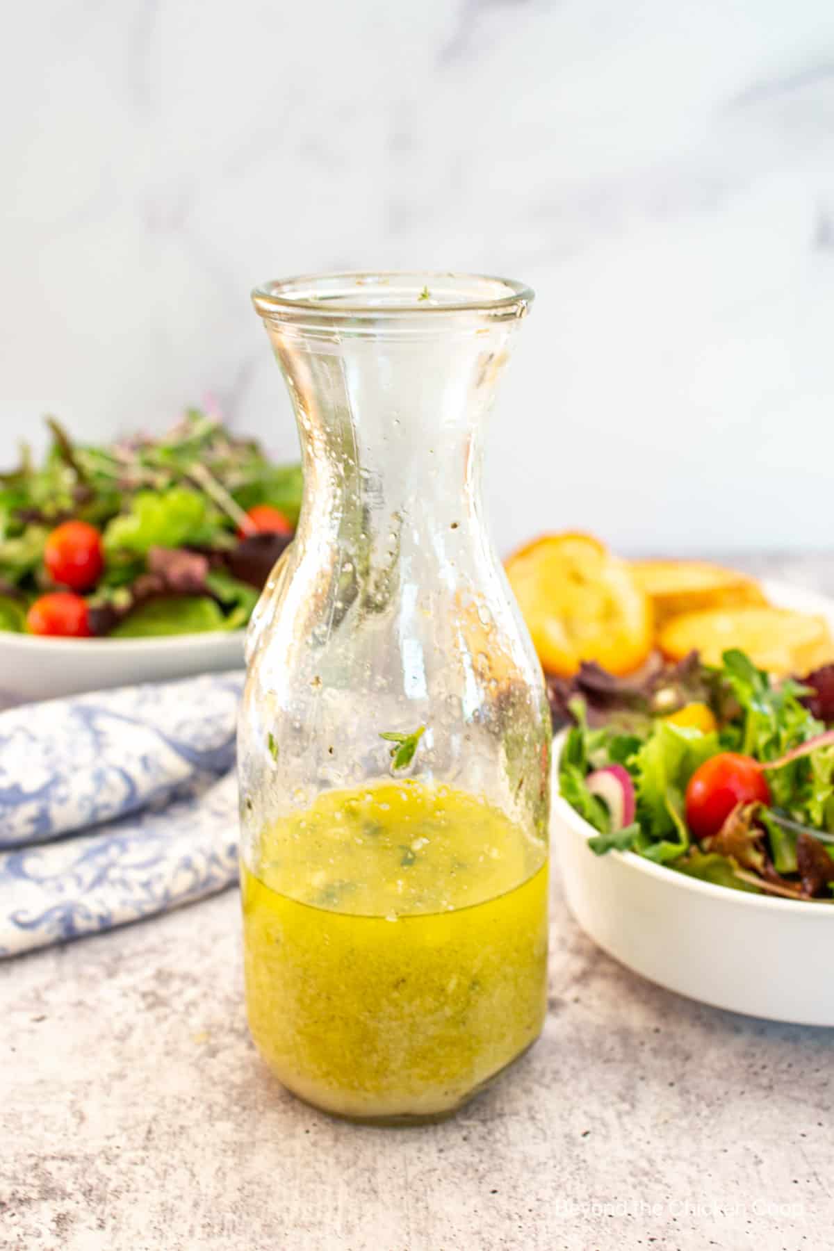 A decanter filled with a yellow dressing.