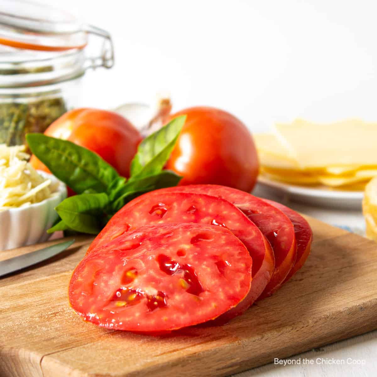 Sliced tomatoes on a wooden board.