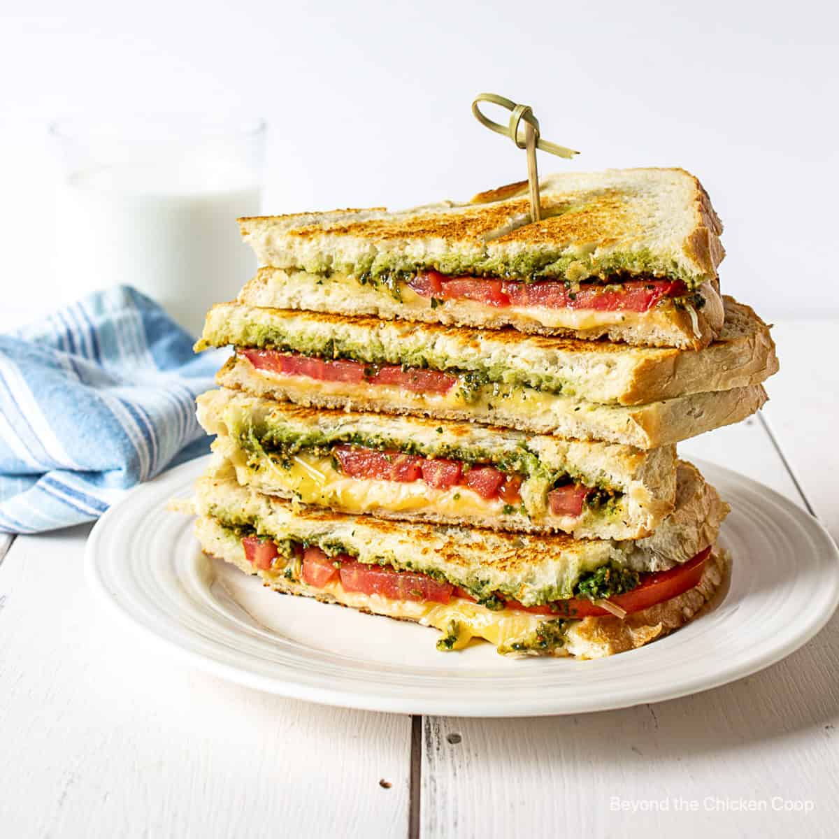 A grilled cheese sandwich with tomatoes and pesto.